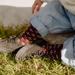 Baby wearing Lamington merino knee high socks in fig with lilac cross pattern made in New Zealand.