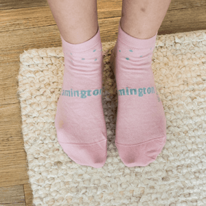 Woman wearing Lamington women's merino ankle socks in blush pink with soft green spots made in New Zealand.