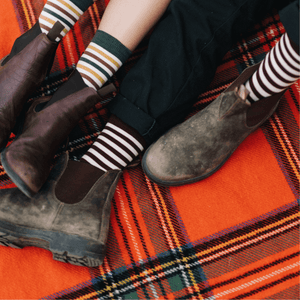 feet on a picnic blanket wearing maroon and oatmeal striped socks