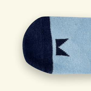 Close-up view of Merino Wool Baby Socks, featuring a blue and navy design with Mosey logo pattern.