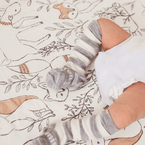 Merino Wool Knee High Socks for Baby in Pebble with grey stripes on a soft patterned blanket.