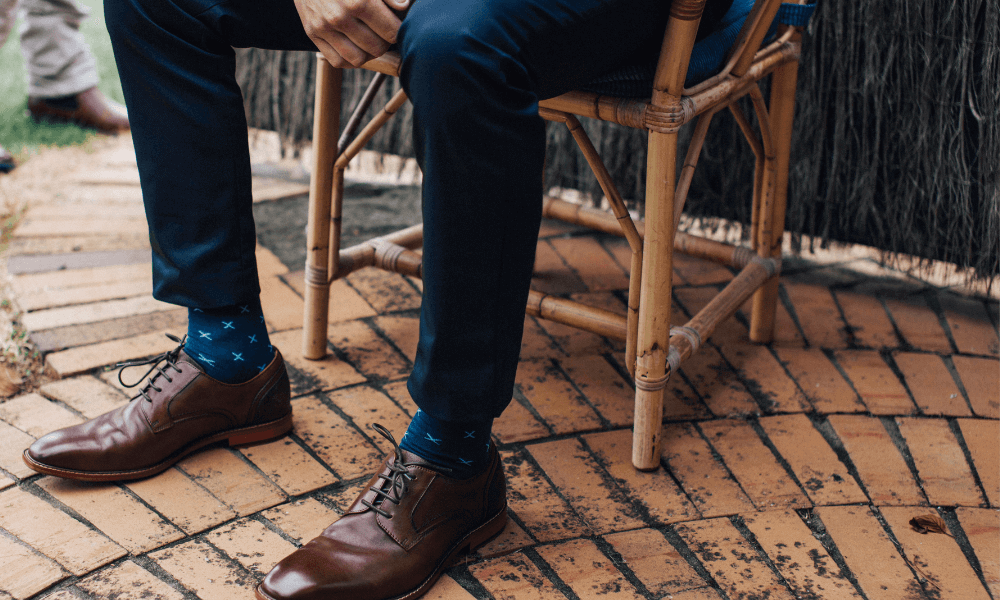 Matching dress socks with shoes and pants in a stylish outfit featuring brown shoes and patterned socks.