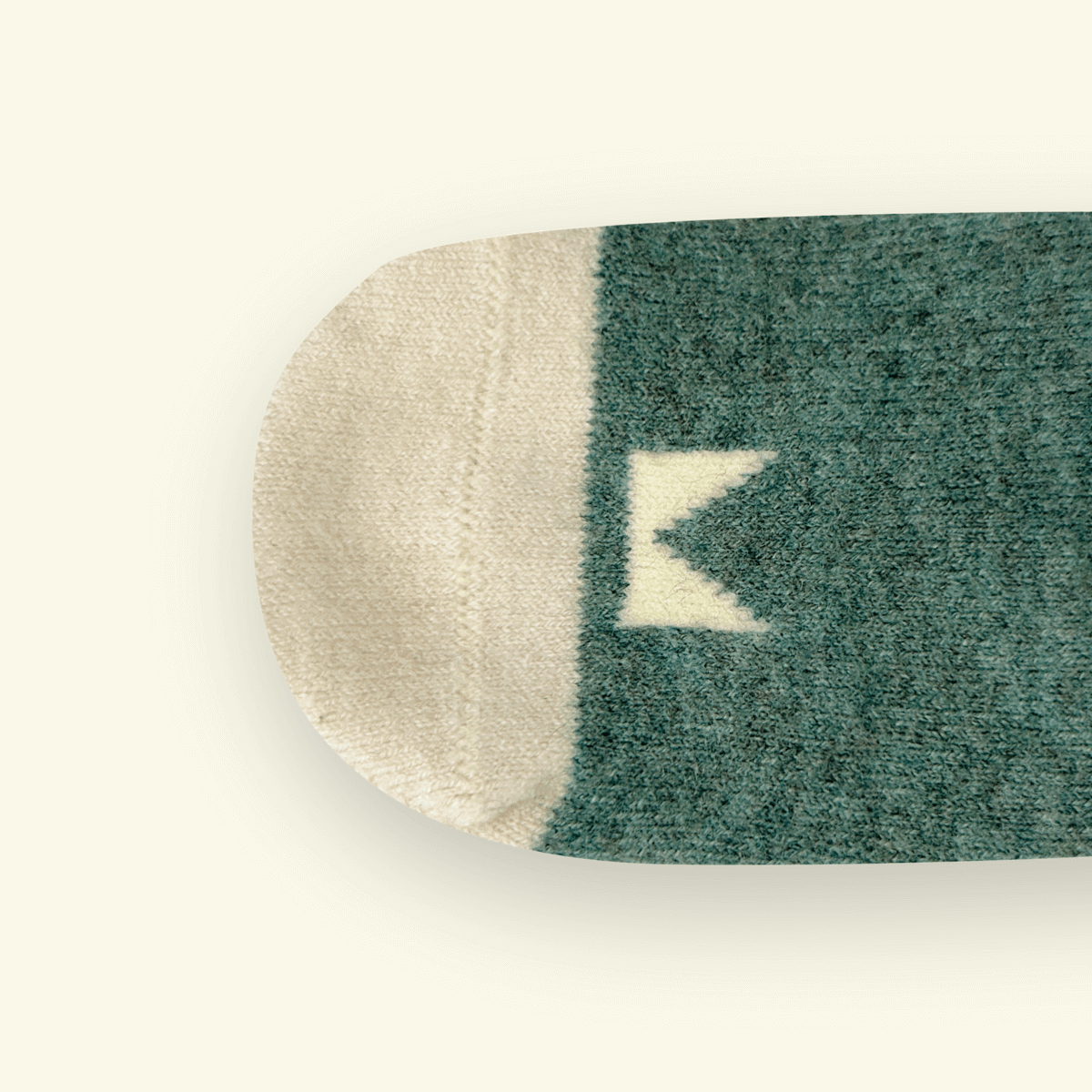 Close-up of Merino Wool Baby Socks in Rook showing logo pattern and color blend.