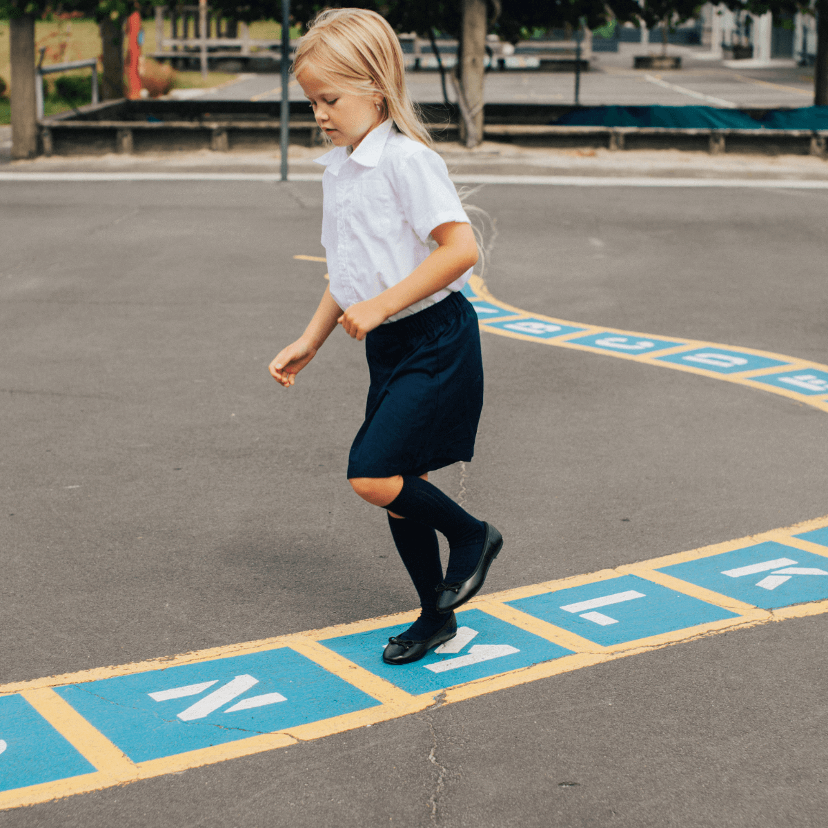 Child wearing Merino Wool Knee High Socks playing hopscotch outdoors.